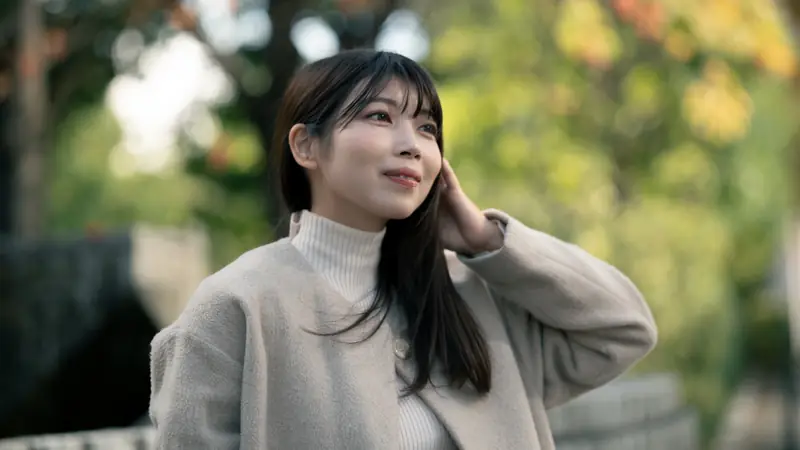 秋の木漏れ日の中で微笑む女性の屋外ポートレート(制作実績)